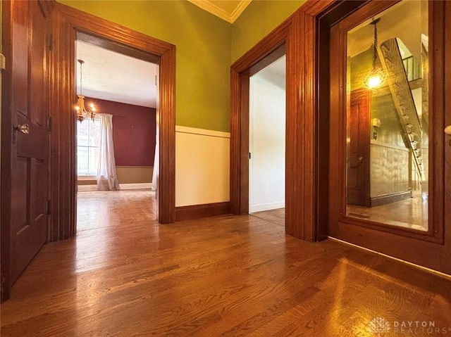 142 W Church St, Xenia, OH 45385 - corridor with wood finished floors, ornamental molding, a chandelier, and baseboards