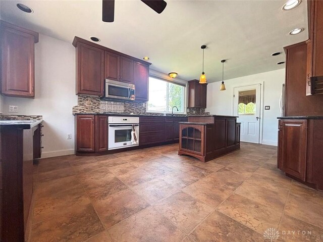 142 W Church St, Xenia, OH 45385 - kitchen featuring white oven, a sink, baseboards, dark countertops, and recessed lighting