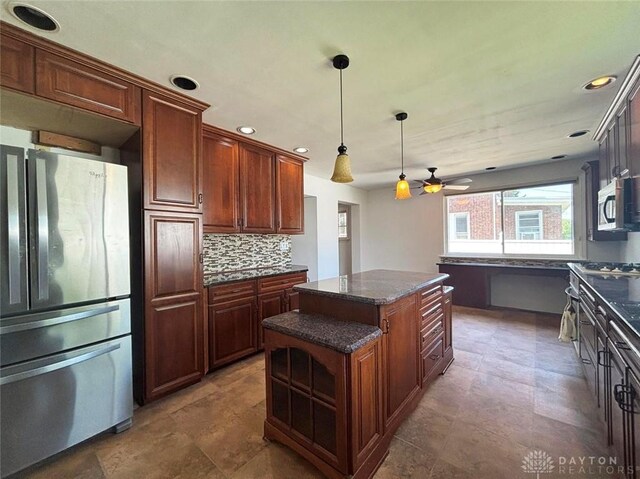 142 W Church St, Xenia, OH 45385 - kitchen featuring stainless steel appliances, a kitchen island, backsplash, pendant lighting, and ceiling fan