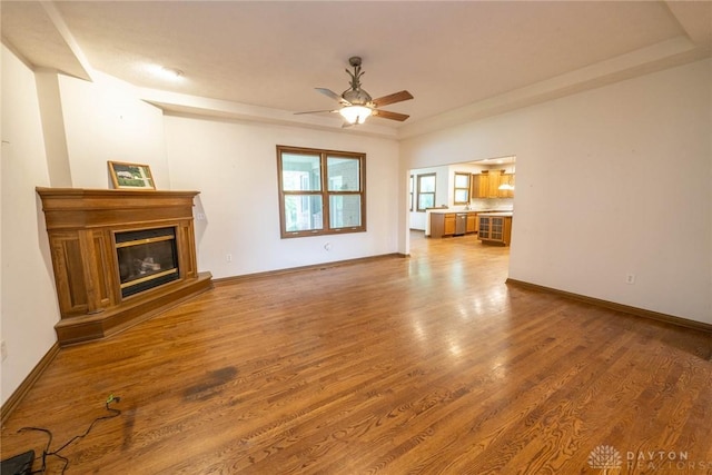 9062 Adam Ln, Waynesville, OH 45068 - unfurnished living room with ceiling fan, a glass covered fireplace, wood finished floors, and baseboards
