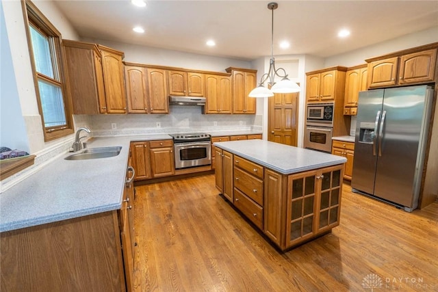 9062 Adam Ln, Waynesville, OH 45068 - kitchen featuring stainless steel appliances, a sink, a center island, under cabinet range hood, and brown cabinetry