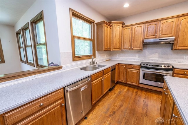 9062 Adam Ln, Waynesville, OH 45068 - kitchen with appliances with stainless steel finishes, a sink, under cabinet range hood, dark wood finished floors, and light countertops