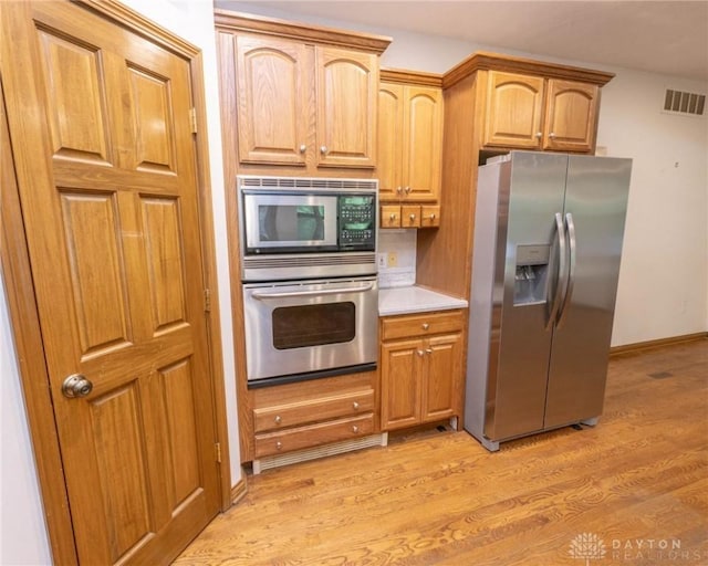 9062 Adam Ln, Waynesville, OH 45068 - kitchen with appliances with stainless steel finishes, light wood-style floors, light countertops, and baseboards