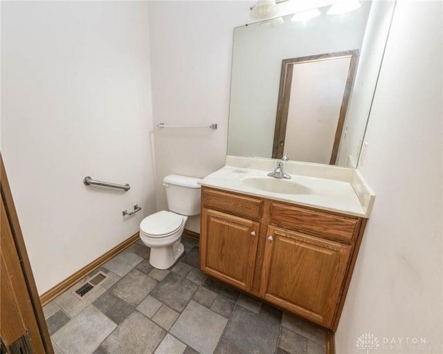 9062 Adam Ln, Waynesville, OH 45068 - half bathroom featuring vanity, toilet, stone finish flooring, and baseboards