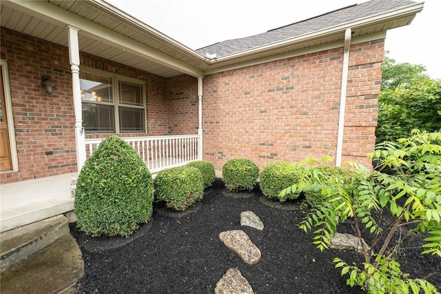 9062 Adam Ln, Waynesville, OH 45068 - view of property exterior with a porch, brick siding, and a shingled roof