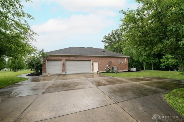 9062 Adam Ln, Waynesville, OH 45068 - view of side of property with concrete driveway, a lawn, an attached garage, brick siding, and central air condition unit