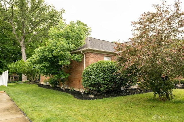 9062 Adam Ln, Waynesville, OH 45068 - view of side of home featuring brick siding, a lawn, and a shingled roof
