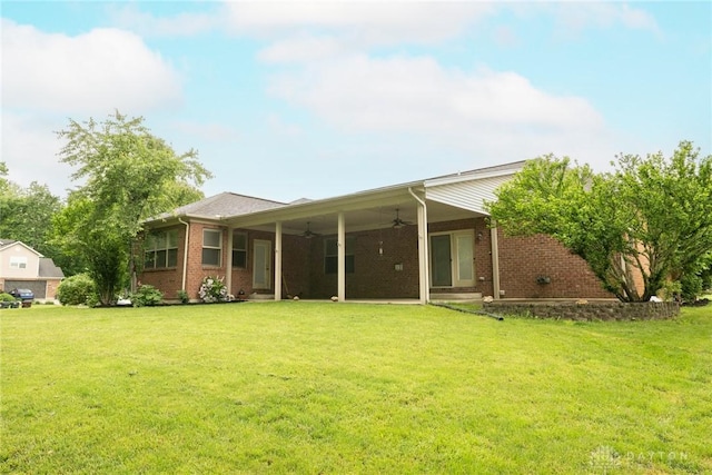 9062 Adam Ln, Waynesville, OH 45068 - back of house featuring a ceiling fan, a yard, and brick siding
