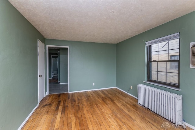 515 Aberdeen Ave, Dayton, OH 45419 - unfurnished room featuring radiator heating unit, hardwood / wood-style floors, and a textured ceiling
