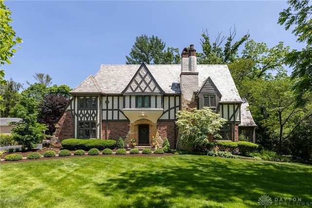 1500 Ridgeway Rd, Oakwood, OH 45419 - tudor-style house with a front yard, stucco siding, a chimney, and brick siding