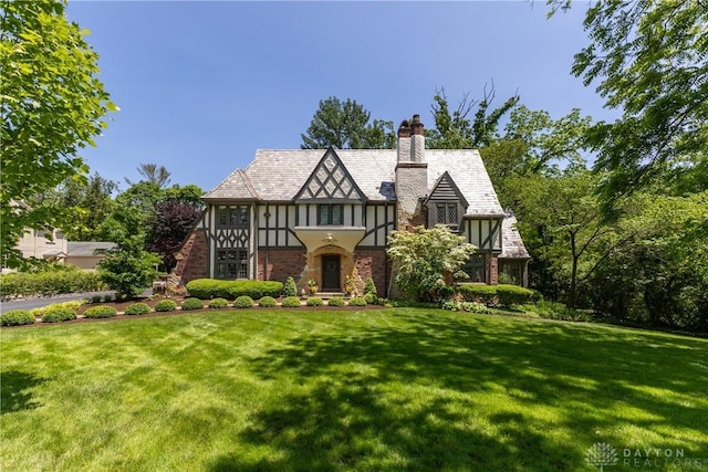 1500 Ridgeway Rd, Oakwood, OH 45419 - tudor-style house with a front yard, a chimney, and stucco siding