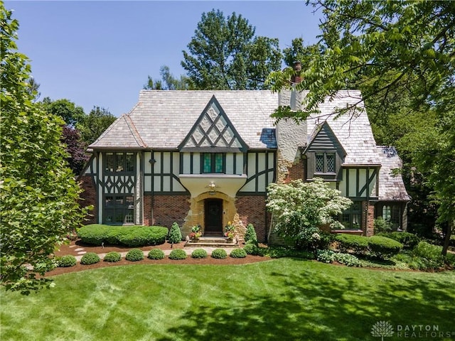 1500 Ridgeway Rd, Oakwood, OH 45419 - tudor home with a front yard, a chimney, stucco siding, a high end roof, and brick siding