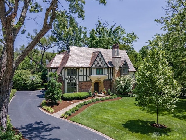 1500 Ridgeway Rd, Oakwood, OH 45419 - tudor home featuring a front lawn, a chimney, and brick siding