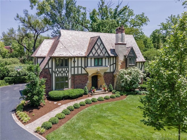 1500 Ridgeway Rd, Oakwood, OH 45419 - tudor home with stucco siding, a chimney, a front yard, and brick siding