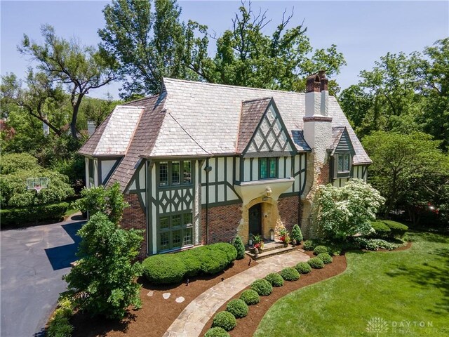 1500 Ridgeway Rd, Oakwood, OH 45419 - tudor-style house with a chimney, stucco siding, a front yard, driveway, and brick siding