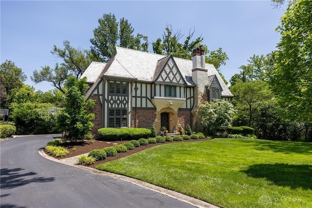 1500 Ridgeway Rd, Oakwood, OH 45419 - tudor-style house with a front yard, a chimney, stucco siding, and brick siding