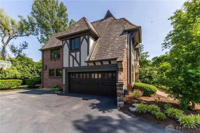 1500 Ridgeway Rd, Oakwood, OH 45419 - view of front facade with asphalt driveway, a garage, stucco siding, and brick siding