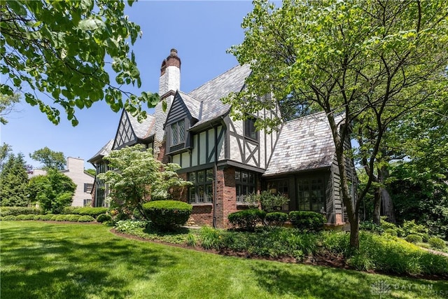 1500 Ridgeway Rd, Oakwood, OH 45419 - view of property exterior with a yard, a high end roof, a chimney, and brick siding