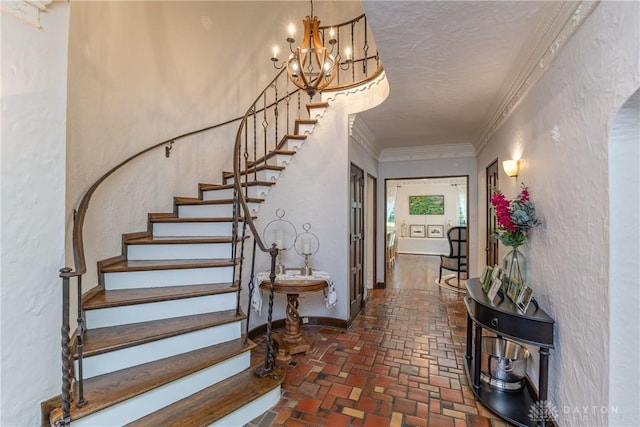 1500 Ridgeway Rd, Oakwood, OH 45419 - stairway with a chandelier, brick flooring, a textured ceiling, crown molding, and baseboards