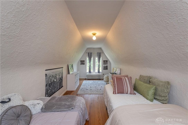 1500 Ridgeway Rd, Oakwood, OH 45419 - bedroom featuring radiator heating unit, wood finished floors, a textured wall, and lofted ceiling