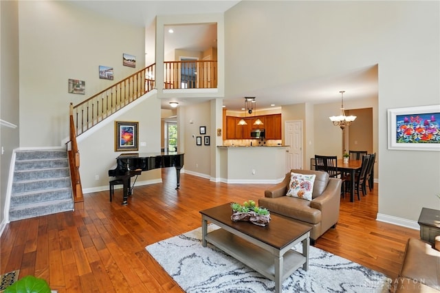 10041 Meadow Woods Ln, Washington Twp, OH 45458 - living area with a chandelier, hardwood / wood-style floors, stairs, a high ceiling, and baseboards
