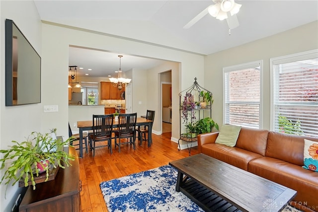 10041 Meadow Woods Ln, Washington Twp, OH 45458 - living room featuring a chandelier, light wood-style flooring, a ceiling fan, lofted ceiling, and baseboards