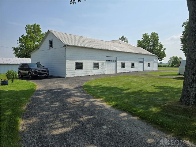 383 Georgetown Verona Rd, West Manchester, OH 45382 - view of home's exterior featuring a lawn, an outbuilding, metal roof, and a detached garage