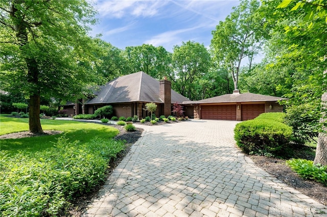1211 Runnymede Rd, Oakwood, OH 45419 - view of front of property with decorative driveway, an attached garage, a front yard, and a chimney