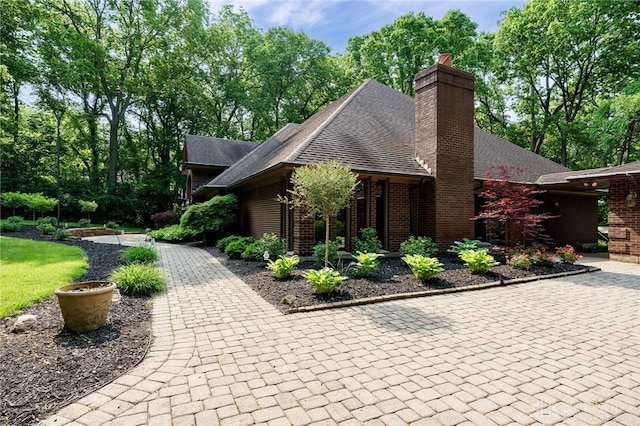 1211 Runnymede Rd, Oakwood, OH 45419 - view of home's exterior with a chimney, brick siding, and a shingled roof