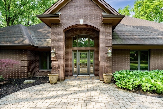 1211 Runnymede Rd, Oakwood, OH 45419 - property entrance featuring brick siding, roof with shingles, and a patio