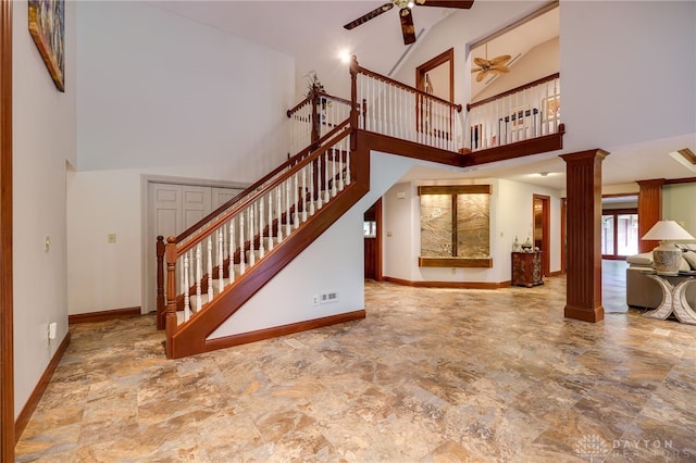1211 Runnymede Rd, Oakwood, OH 45419 - unfurnished living room with decorative columns, ceiling fan, a high ceiling, baseboards, and stairway