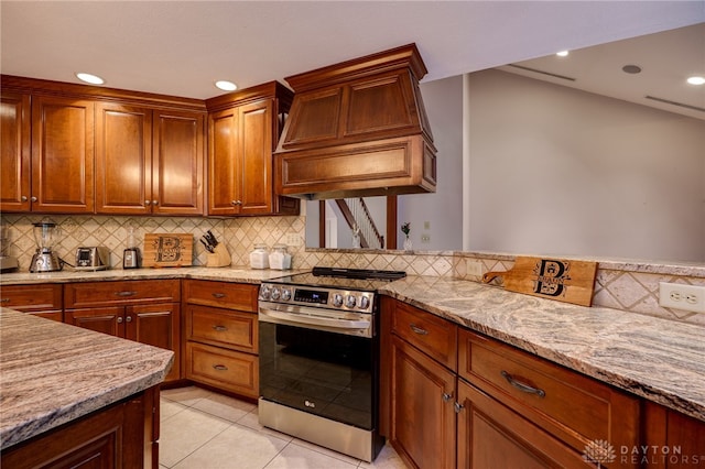 1211 Runnymede Rd, Oakwood, OH 45419 - kitchen featuring stainless steel range with electric cooktop, premium range hood, decorative backsplash, light stone counters, and light tile patterned floors