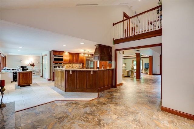 1211 Runnymede Rd, Oakwood, OH 45419 - kitchen with a peninsula, stainless steel built in fridge, decorative columns, baseboards, and brown cabinetry