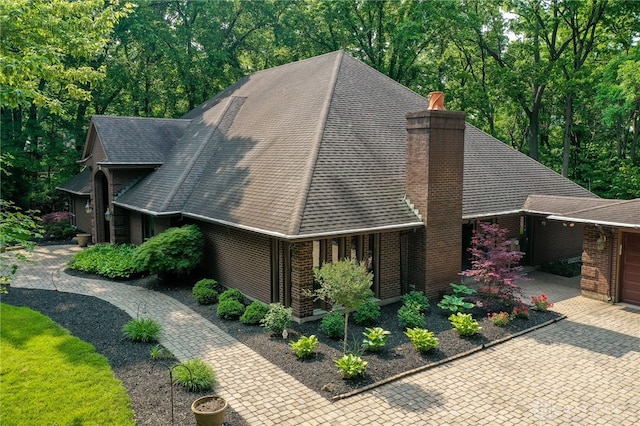 1211 Runnymede Rd, Oakwood, OH 45419 - view of home's exterior featuring brick siding, a chimney, and roof with shingles