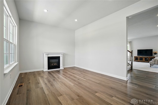 2550 Bellevue Dr, Batavia, OH 45103 - unfurnished living room with a glass covered fireplace, wood finished floors, recessed lighting, stairs, and baseboards