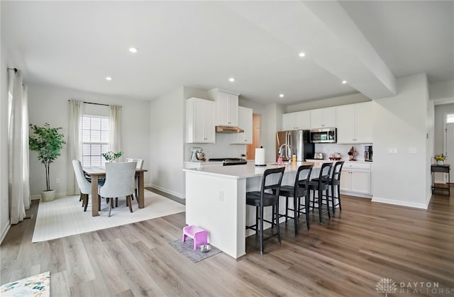2550 Bellevue Dr, Batavia, OH 45103 - kitchen with appliances with stainless steel finishes, baseboards, light wood-style floors, a center island with sink, and recessed lighting