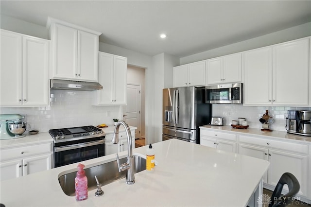 2550 Bellevue Dr, Batavia, OH 45103 - kitchen featuring stainless steel appliances, under cabinet range hood, decorative backsplash, a sink, and white cabinets