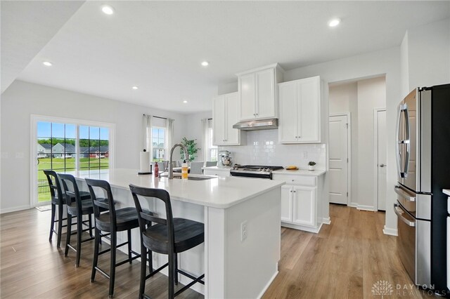 2550 Bellevue Dr, Batavia, OH 45103 - kitchen with appliances with stainless steel finishes, a sink, under cabinet range hood, a center island with sink, and light wood finished floors