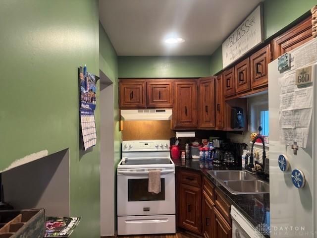 224 S Wolf Creek St, Brookville, OH 45309 - kitchen with white appliances, under cabinet range hood, a sink, and dark countertops