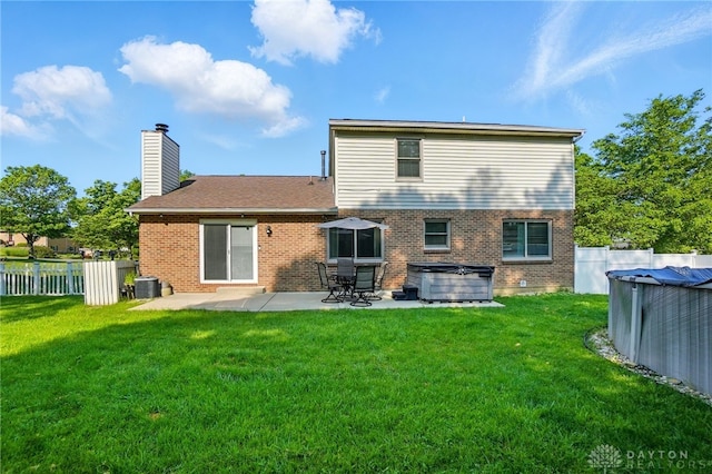712 S Linden Ave, Miamisburg, OH 45342 - back of property featuring a hot tub, brick siding, a chimney, a patio, and central AC