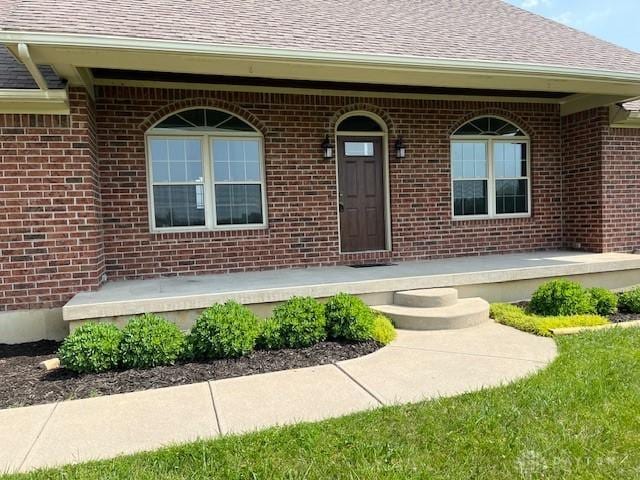 5671 Sonora Rd, Lewisburg, OH 45338 - entrance to property with a shingled roof, brick siding, and covered porch