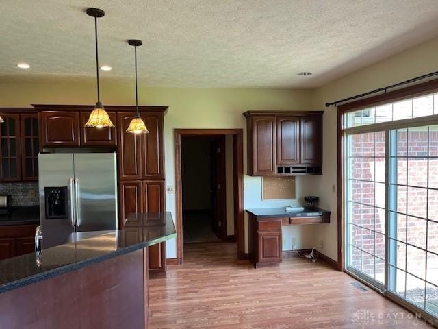 5671 Sonora Rd, Lewisburg, OH 45338 - kitchen with stainless steel fridge with ice dispenser, a textured ceiling, baseboards, light wood-style flooring, and tasteful backsplash