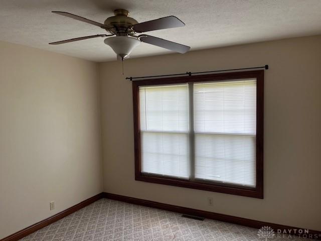 5671 Sonora Rd, Lewisburg, OH 45338 - unfurnished room with baseboards, a ceiling fan, and light colored carpet