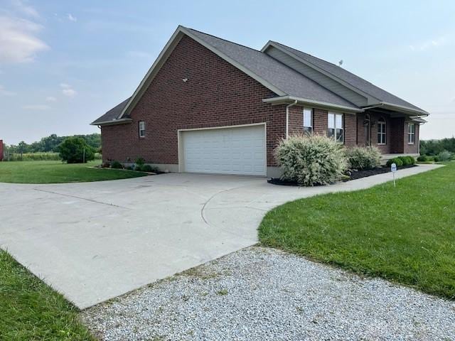 5671 Sonora Rd, Lewisburg, OH 45338 - view of home's exterior with concrete driveway, brick siding, an attached garage, and a yard