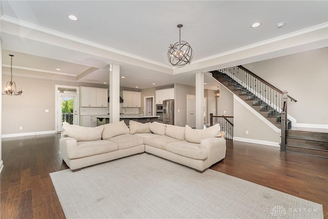 5411 Whispering Brook Ct, Liberty Twp, OH 45011 - living room featuring a chandelier, dark wood-style flooring, baseboards, stairs, and ornamental molding