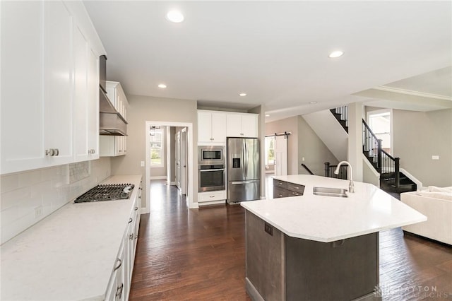 5411 Whispering Brook Ct, Liberty Twp, OH 45011 - kitchen with appliances with stainless steel finishes, a sink, a barn door, dark wood finished floors, and tasteful backsplash