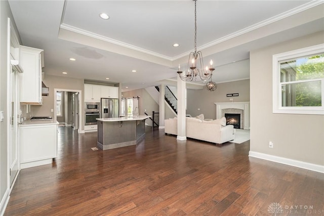 5411 Whispering Brook Ct, Liberty Twp, OH 45011 - living area with ornamental molding, stairway, a chandelier, dark wood-style floors, and a glass covered fireplace
