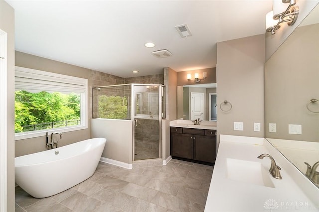 5411 Whispering Brook Ct, Liberty Twp, OH 45011 - bathroom with a shower stall, two vanities, a soaking tub, recessed lighting, and baseboards