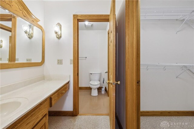 4384 New Market Banta Rd, Lewisburg, OH 45338 - full bath featuring vanity, a walk in closet, toilet, and baseboards