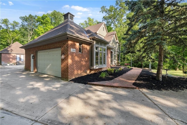 4384 New Market Banta Rd, Lewisburg, OH 45338 - view of side of home featuring brick siding, concrete driveway, and an attached garage